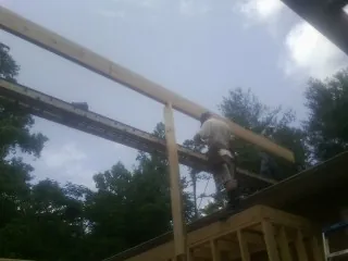 Carpenter setting a ridge beam over a new addition frame — Ice Dam Removal by Roofing Brothers in Poncha Springs