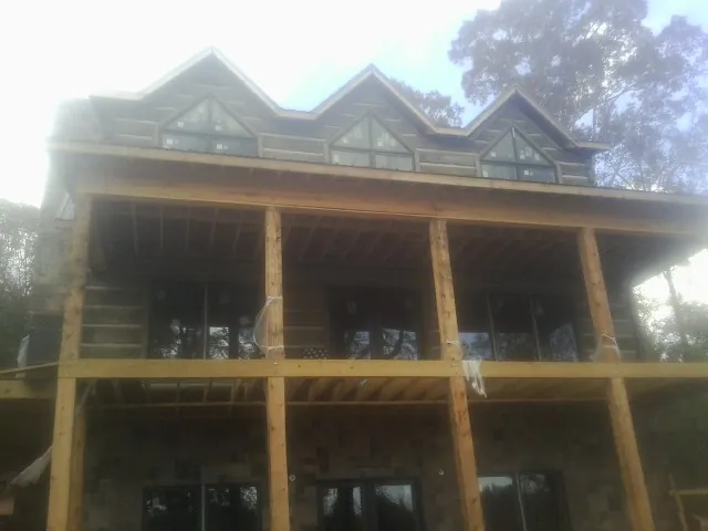 Dormers and porch framing on a large log home under construction — Roof Coating work by our crew in Poncha Springs