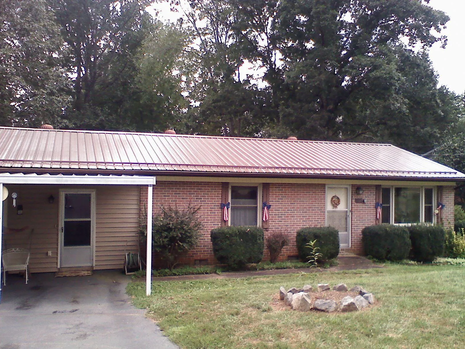 Bronze metal roof and carport on a brick ranch home — Roof Repair work by our crew in Poncha Springs